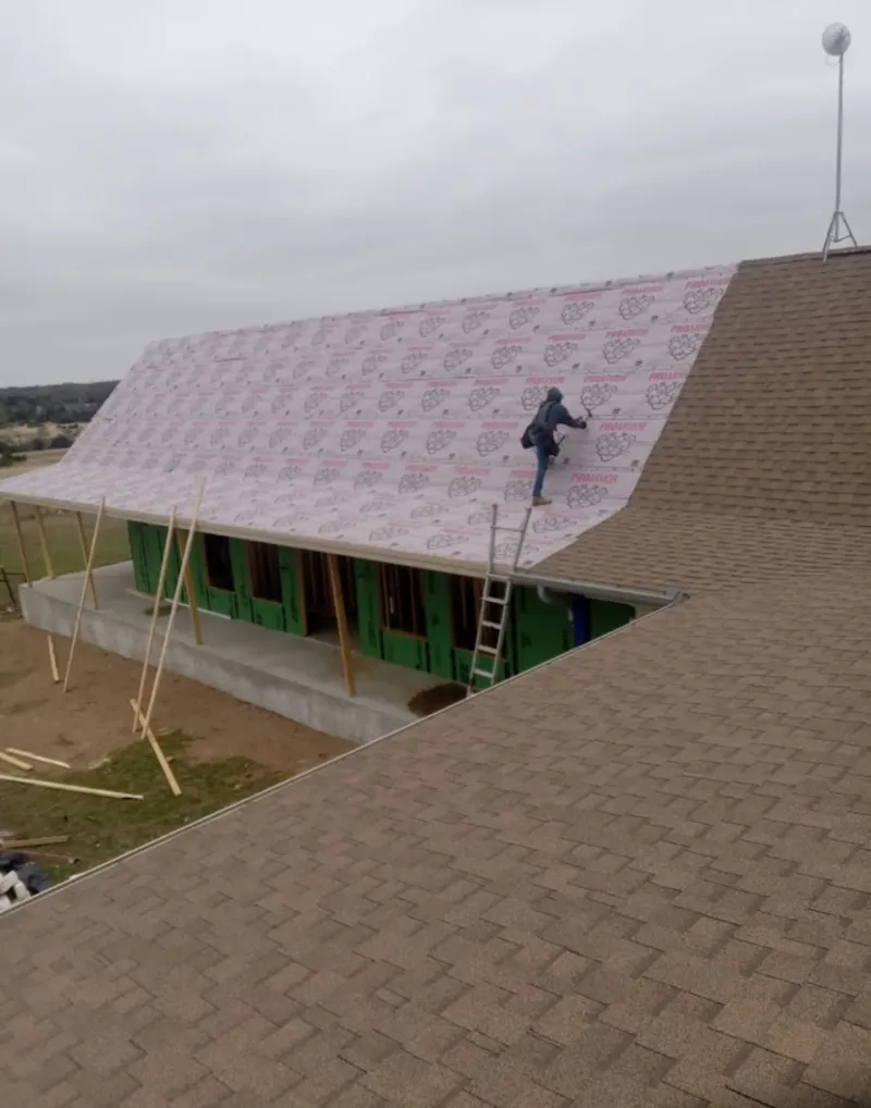 Worker preparing underlayment for a metal roof installation in Lower Allen